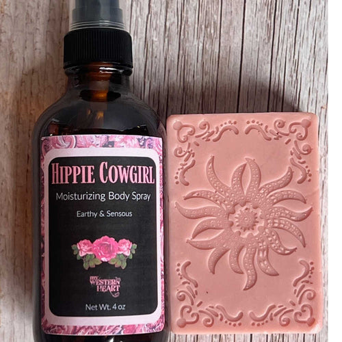 Hippie Cowgirl body spray bottle and pink soap bar with floral design on a wooden surface