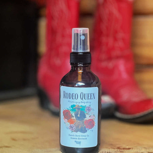 Bottle of 'Rodeo Queen' spray with cowboy boots in the background